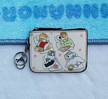 Coin purse featuring cute cats getting ready for bed